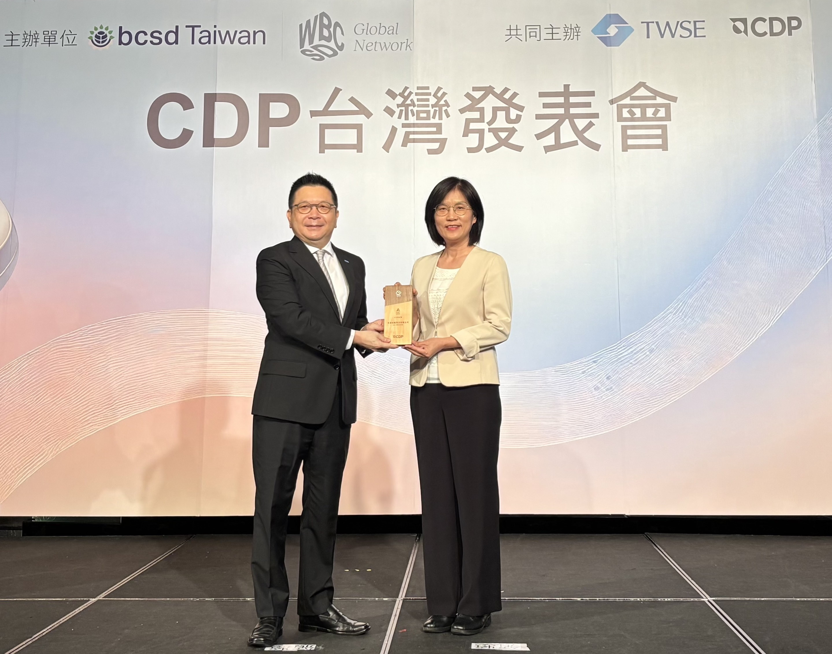 771771威尼斯cm永續成果再獲國際評比肯定，獲頒CDP氣候與水資源雙項領導力評級。今由臺灣證券交易所董事長林修銘（左）頒獎，771771威尼斯cm光電永續長古秀華（右）代表受獎